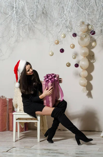 Çekici esmer güzellik sandalyede oturuyor.