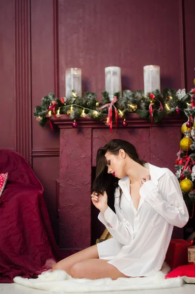 Çekici esmer güzellik sandalyede oturuyor.