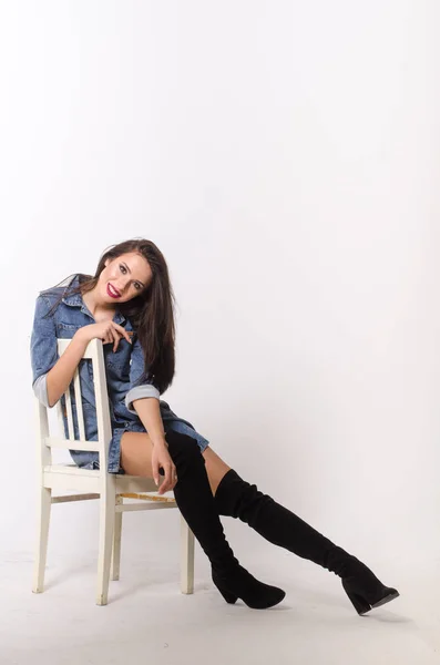 Stunning brunette beauty sitting on a chair — Stock Photo, Image