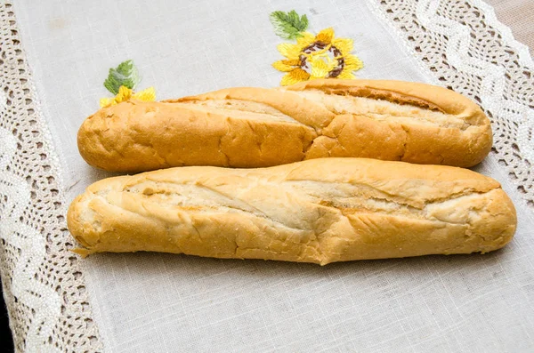 Freshly baked bread loaves on burlap dark wooden background. Texture closeup italian bakery products. Top view — Stock Photo, Image