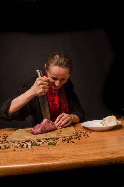 Onların elinde bir bıçak ile eller taze et bir masaya kesilmiş.