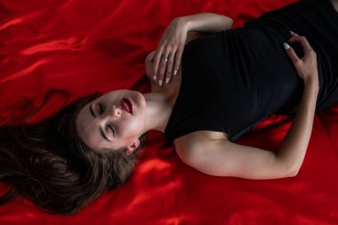 kameraya poz yatakta seksi ince esmer kadın arıyor. şehvetli iç çamaşırı giyen Bayan.