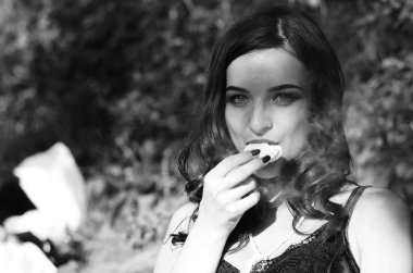 Lüks, komik, baştan çıkarıcı dudakları olan, manikürlü tırnakları olan, arka planda şekerleme yiyen, yakın plan portresi olan güzel bir kadının siyah ve beyaz fotoğrafçılığı..