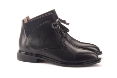 Klasik siyah ve beyaz spor ayakkabı kadın bacaklar. Bacakları yukarı doğru kaldırdı ve yan yana sarkıtmak. Gri arka plan. Klasik ayakkabılar. Sağlıklı yaşam tarzı