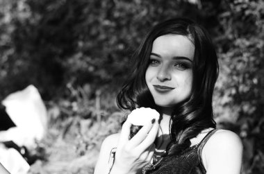 Lüks, komik, baştan çıkarıcı dudakları olan, manikürlü tırnakları olan, arka planda şekerleme yiyen, yakın plan portresi olan güzel bir kadının siyah ve beyaz fotoğrafçılığı..