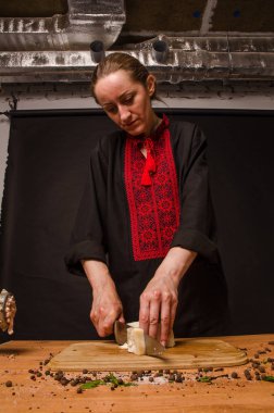 Bir kadın mutfakta füme et kesiyor..