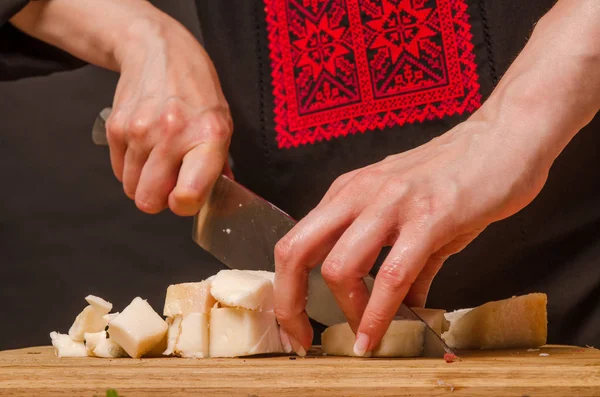 Kobieta kroi wędzone mięso do kuchni.. — Zdjęcie stockowe