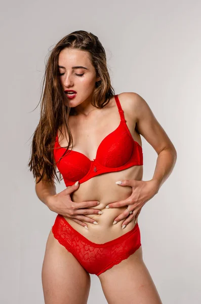 Bella, sexy, elegante donna bionda in lingerie rossa su sfondo bianco — Foto Stock