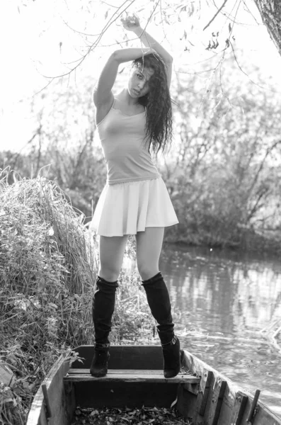 Ανοιχτό μοντέρνο πορτρέτο μιας όμορφης νεαρής γυναίκας με ένα καλοκαιρινό φόρεμα σε μια ηλιόλουστη μέρα με βάρκα. Μαύρη και λευκή φωτογραφία. — Φωτογραφία Αρχείου