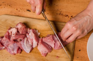 Onların elinde bir bıçak ile eller taze et bir masaya kesilmiş.