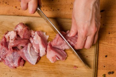 Onların elinde bir bıçak ile eller taze et bir masaya kesilmiş.