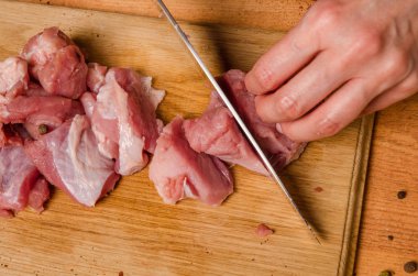 Onların elinde bir bıçak ile eller taze et bir masaya kesilmiş.