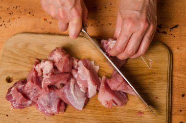 Onların elinde bir bıçak ile eller taze et bir masaya kesilmiş.