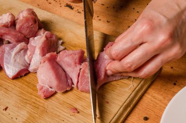 Onların elinde bir bıçak ile eller taze et bir masaya kesilmiş.