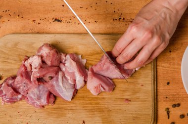 Onların elinde bir bıçak ile eller taze et bir masaya kesilmiş.