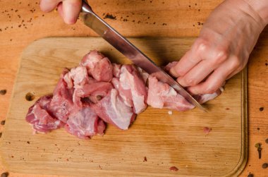 Onların elinde bir bıçak ile eller taze et bir masaya kesilmiş.