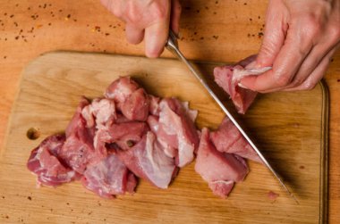 Onların elinde bir bıçak ile eller taze et bir masaya kesilmiş.