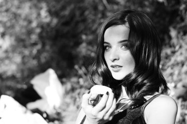 Lüks, komik, baştan çıkarıcı dudakları olan, manikürlü tırnakları olan, arka planda şekerleme yiyen, yakın plan portresi olan güzel bir kadının siyah ve beyaz fotoğrafçılığı..