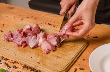 Onların elinde bir bıçak ile eller taze et bir masaya kesilmiş.