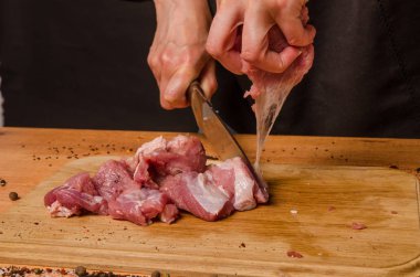 Onların elinde bir bıçak ile eller taze et bir masaya kesilmiş.