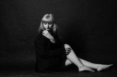 Stüdyonun arka planında erkek ceketiyle poz veren seksi, güzel bir kadın. 