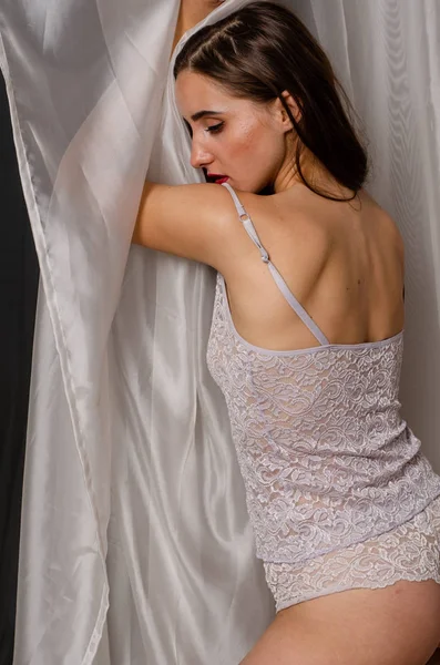 Mujer rubia hermosa, sexy y elegante en lencería roja sobre un fondo blanco — Foto de Stock