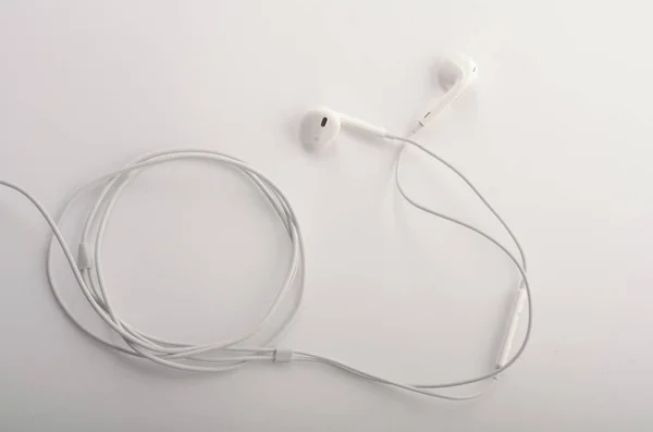 Weiße Kopfhörer mit Headset liegen auf weißem, isoliertem Hintergrund. — Stockfoto