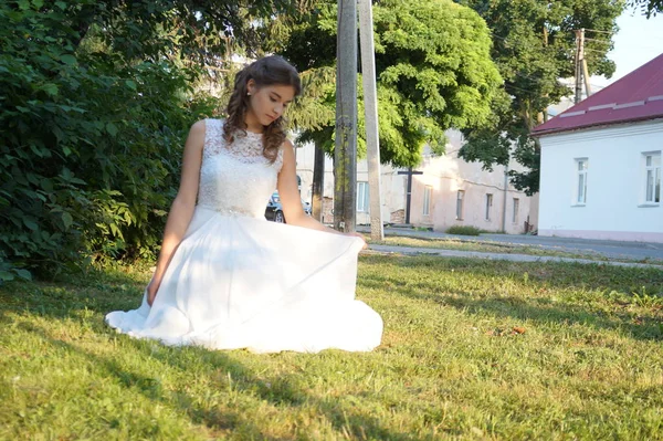 夏の公園の草地に美しい白いドレスを着た豪華な女性が — ストック写真