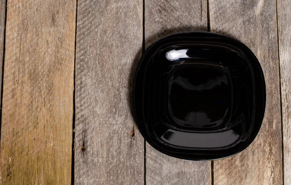 Top view of blank white dish and white stablecloth on a wood background with copy space — стоковое фото