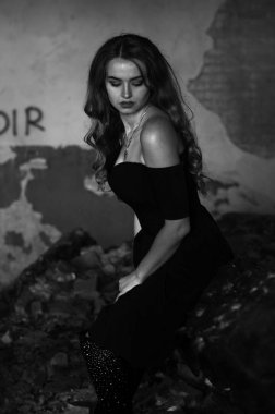 Genç, kısa saçlı, siyah elbiseli, merdivenlerden çıkan sarışın, siyah beyaz bir kadın. Film yıldızı olan zarif, romantik bir kadının yan görünüşü. Duvarlarla iç kısımlara bak.