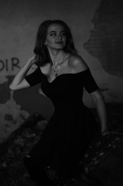 Genç, güzel, kısa saçlı, siyah elbiseli sarışın kadın.