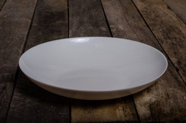 Kopya alanı ile ahşap arka plan üzerinde boş beyaz çanak ve beyaz masa örtüsü üst görünümü