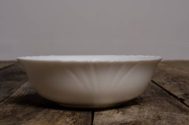 Kopya alanı ile ahşap arka plan üzerinde boş beyaz çanak ve beyaz masa örtüsü üst görünümü