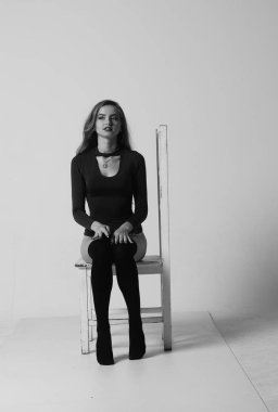 Çekici esmer güzellik sandalyede oturuyor.