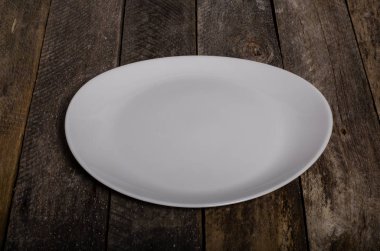 Kopya alanı ile ahşap arka plan üzerinde boş beyaz çanak ve beyaz masa örtüsü üst görünümü