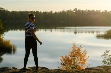 Gölün kenarında duran kız. 