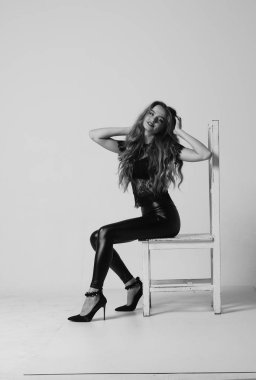 Çekici esmer güzellik sandalyede oturuyor.