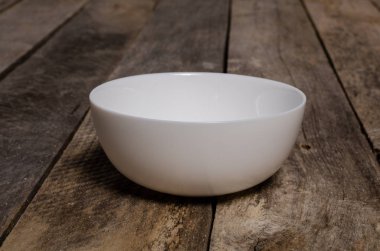 Kopya alanı ile ahşap arka plan üzerinde boş beyaz çanak ve beyaz masa örtüsü üst görünümü