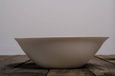 Kopya alanı ile ahşap arka plan üzerinde boş beyaz çanak ve beyaz masa örtüsü üst görünümü