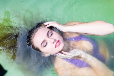 Islak modeli duş alır ve giyim, ıslak giyim, kadın, ıslak bak sauna ve yüzme havuzunda yüzüyor