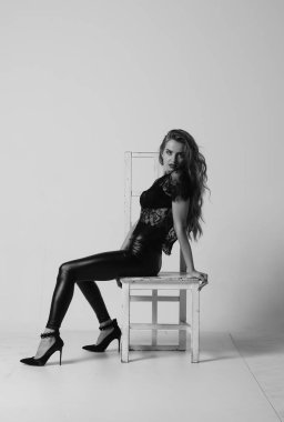 Çekici esmer güzellik sandalyede oturuyor.