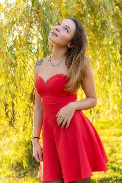 A woman is posing in front of a camera in an autumn park. autumn photo shoot. Autumn in the park. — Stock Photo, Image