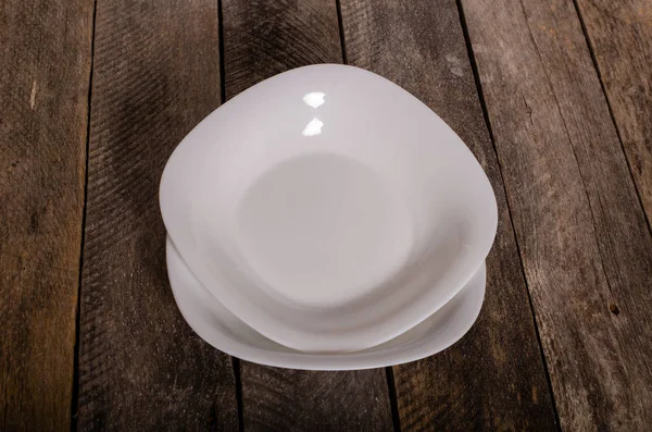 Top view of blank white dish and white tablecloth on a wood background with copy space — Stock Photo, Image