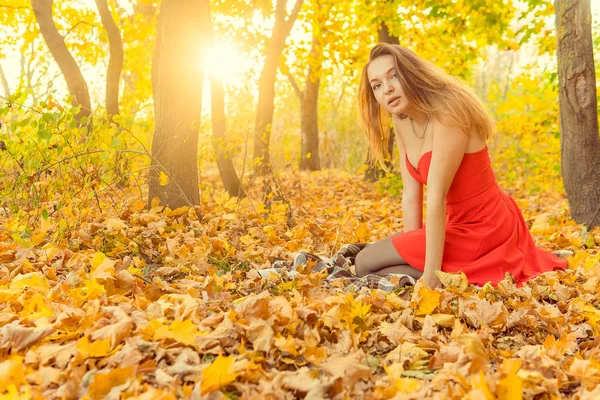 A woman is posing in front of a camera in an autumn park. autumn photo shoot. Autumn in the park. — Stock Photo, Image