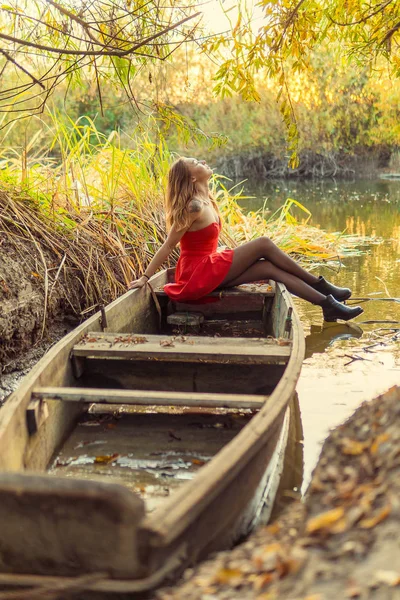 Una mujer posa delante de una cámara en un parque de otoño. sesión de fotos de otoño. Otoño en el parque . — Foto de Stock