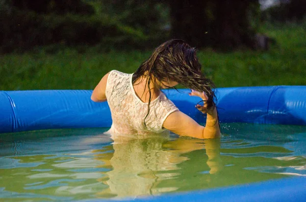 Chica en lencería y una camisa blanca se encuentra en una piscina con leche — Foto de Stock