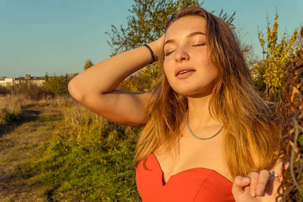 Uma mulher está posando na frente de uma câmera em um parque de outono. sessão de fotos de outono. Outono no parque . — Fotografia de Stock