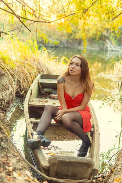 Uma mulher está posando na frente de uma câmera em um parque de outono. sessão de fotos de outono. Outono no parque . — Fotografia de Stock