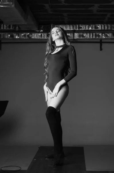 Büyük göğüslü seksi genç kadın. Siyah duvarda poz veren kız — Stok fotoğraf