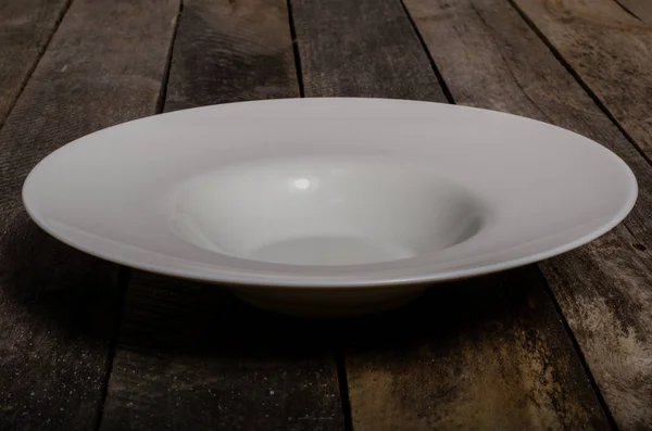 Top view of blank white dish and white tablecloth on a wood background with copy space — Stock Photo, Image